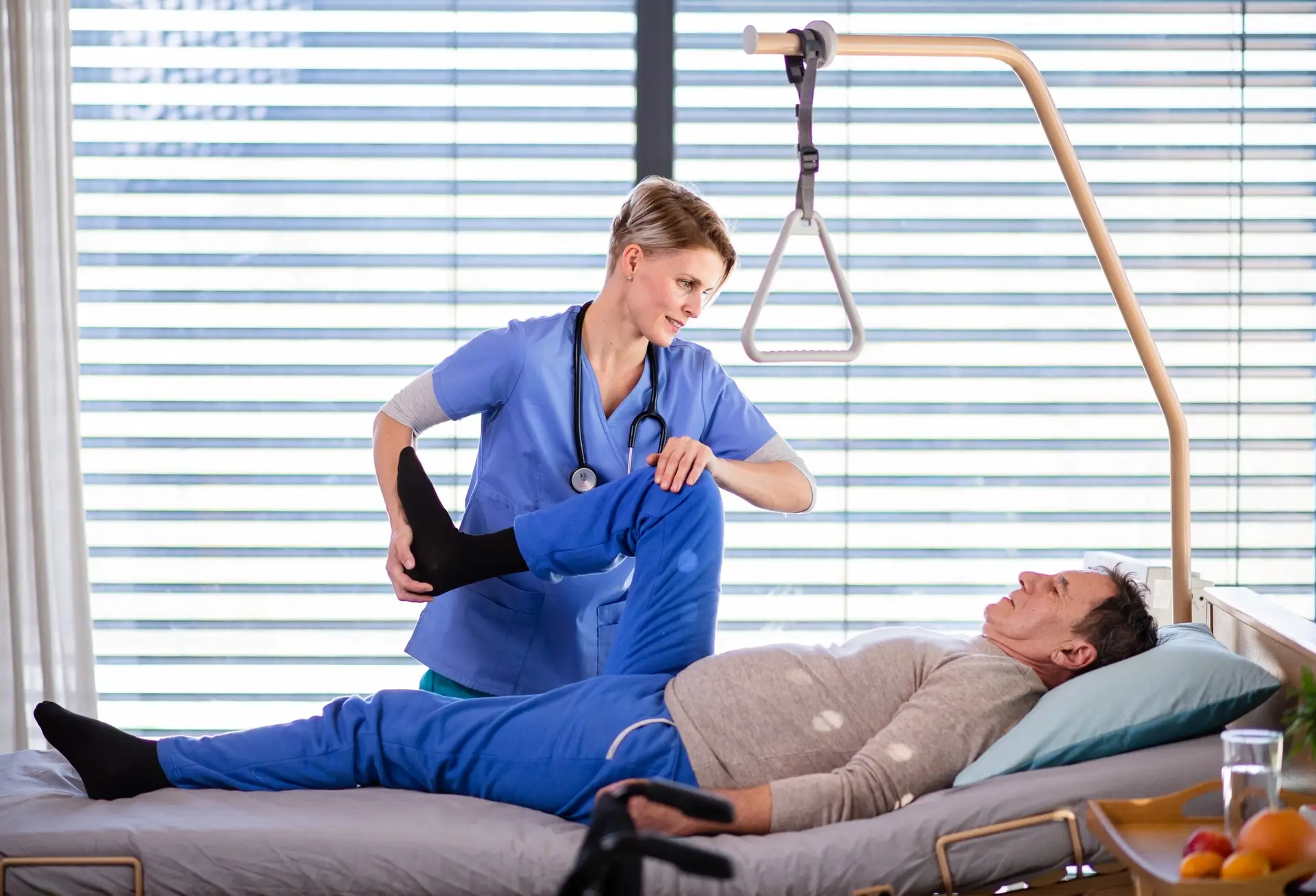 A healthcare worker and senior patient in hospital, physiotherapy.