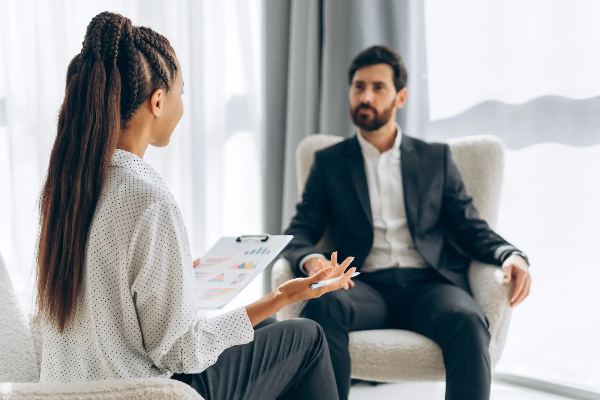 Female psychiatrist, doctor talking with patient, bearded Hispanic man, businessman communication
