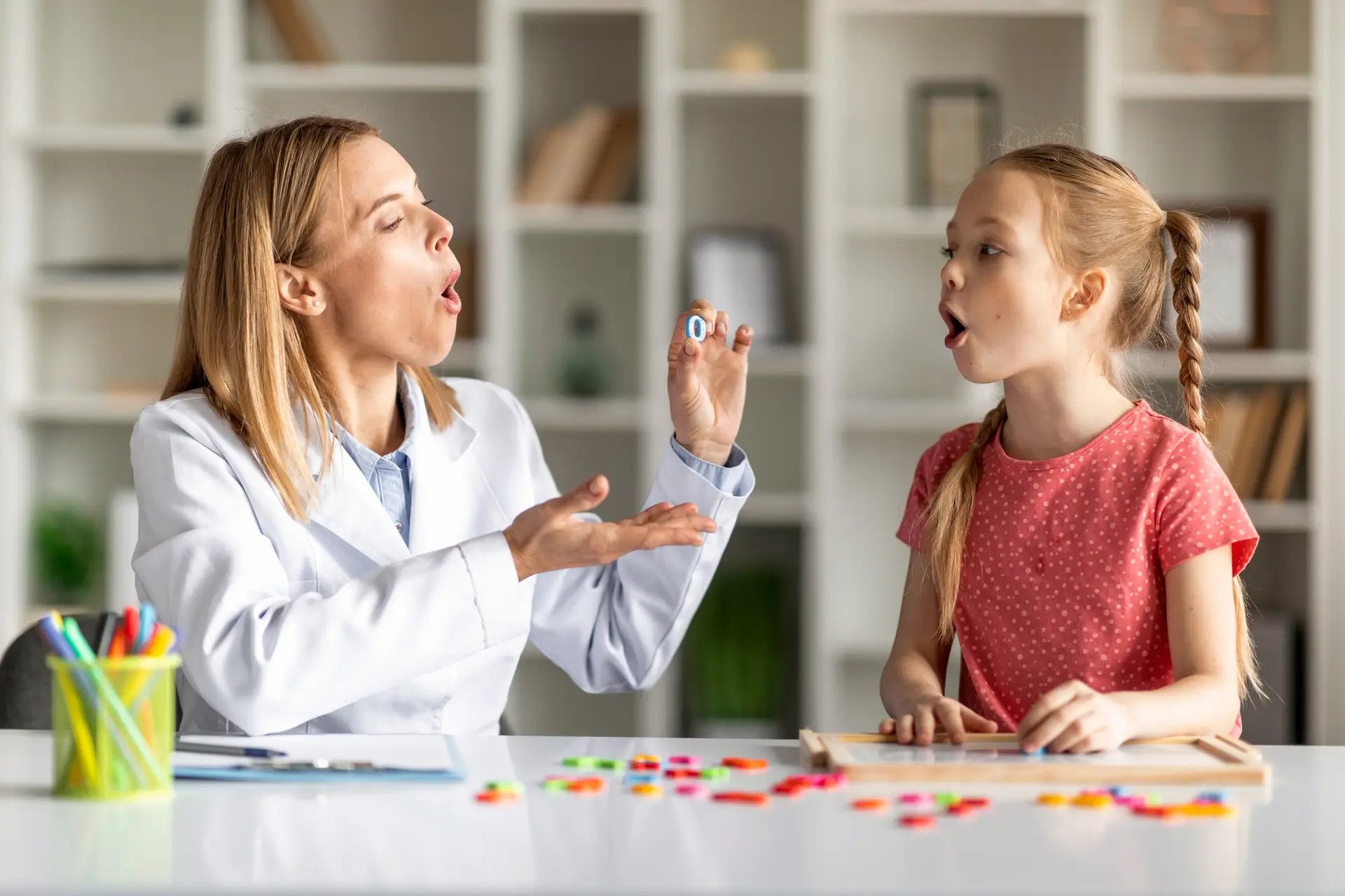 Female Speech Therapist Having Lesson With Cute Little Girl
