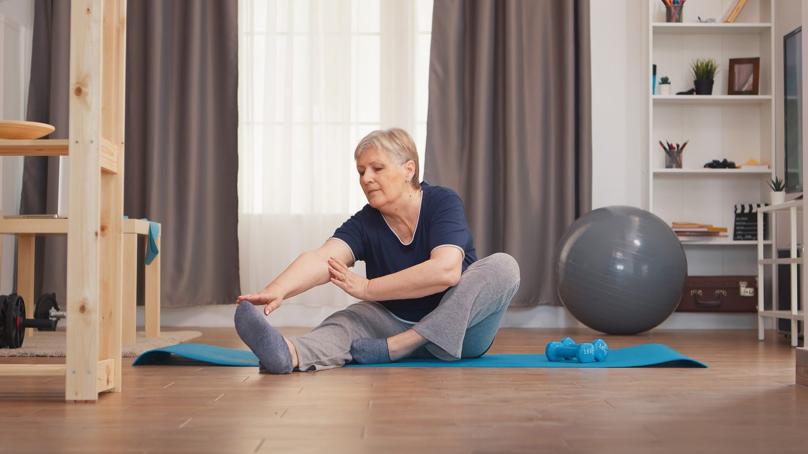 Old woman stretching on yoga mat