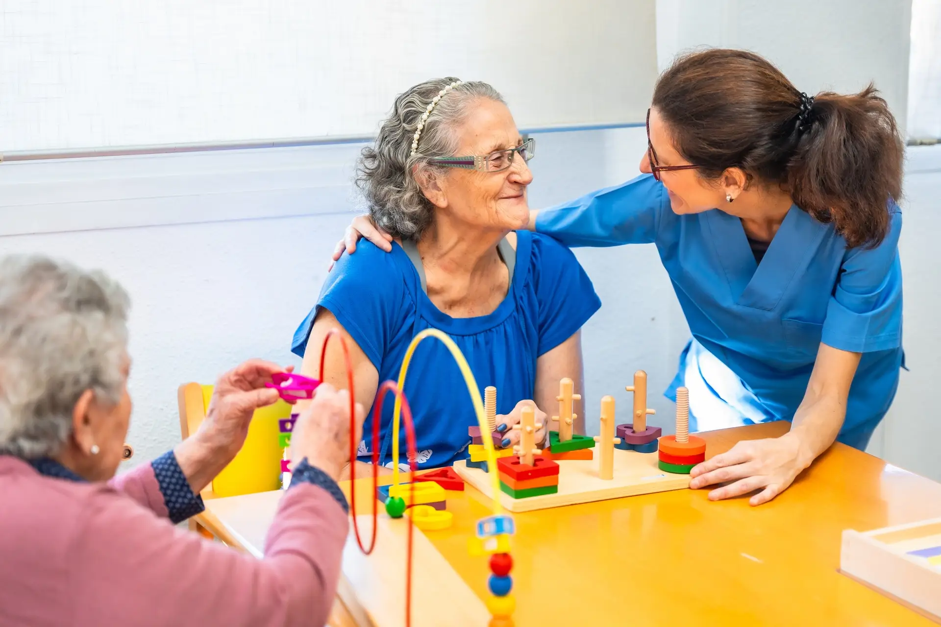 Tender caregiver assisting a senior woman while playing skill games