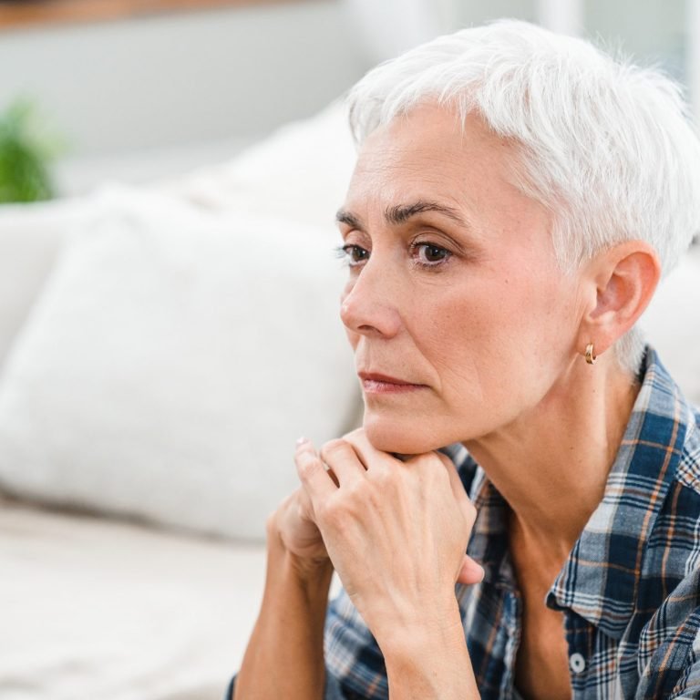 Sad depressed mature woman thinking about negativity and problems at home.